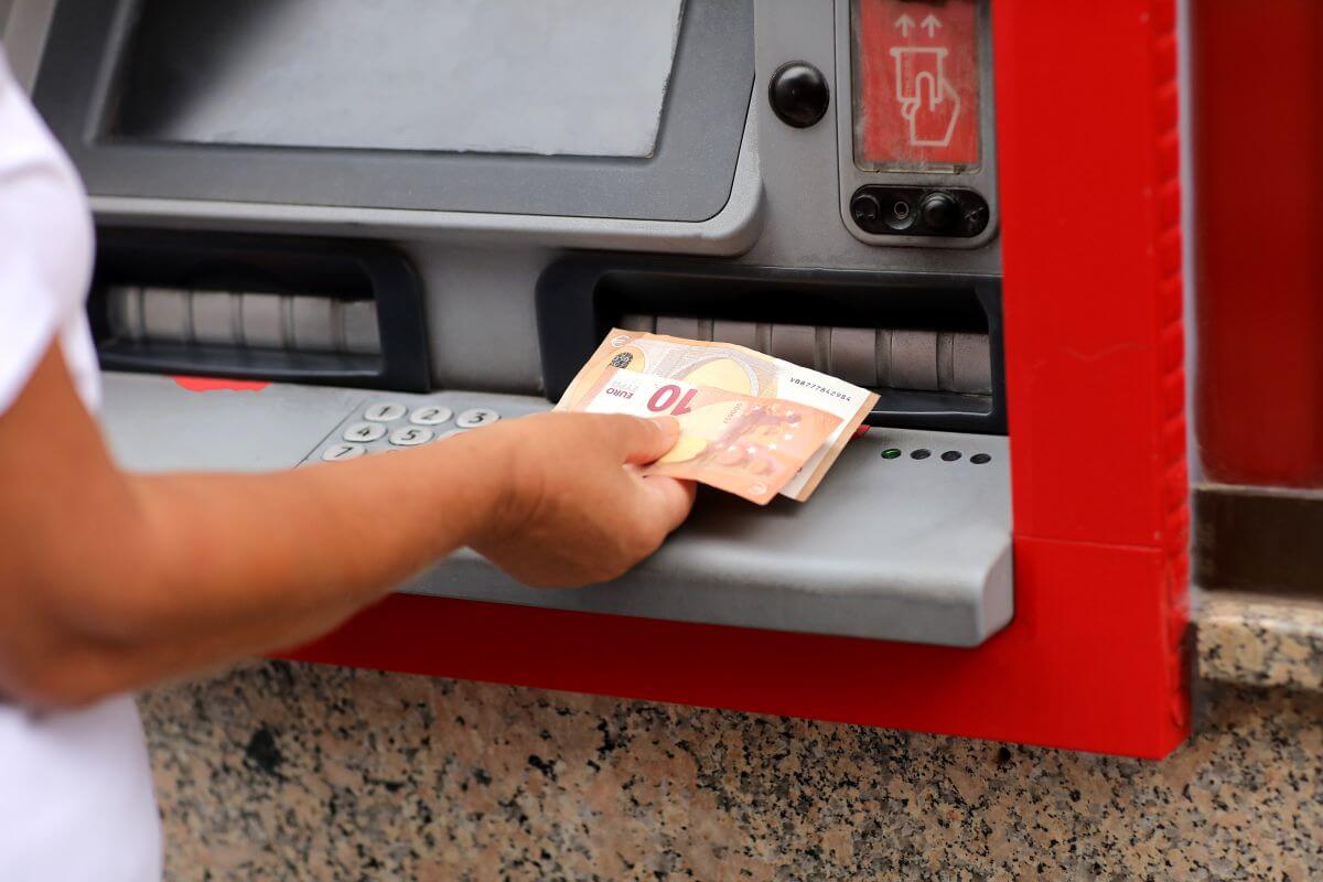 Person withdrawing euros from a cash machine while abroad