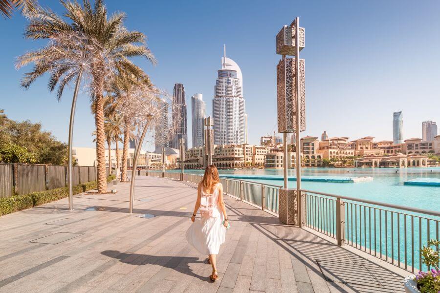 British expat enjoying a family day out in Downtown Dubai near the fountains, surrounded by modern skyscrapers and family-friendly walkways