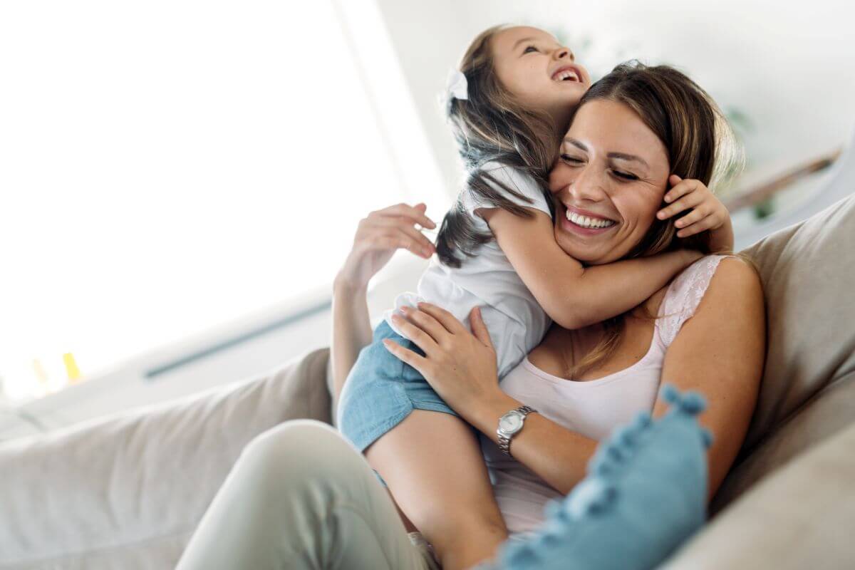 happy child playfully cuddles mother